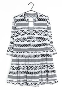 Černobíle vzorované šaty s výstřihem do V, tříčtvrtečními rukávy a vrstveným volánkovým lemem; obsahují geometrické motivy po celé látce.