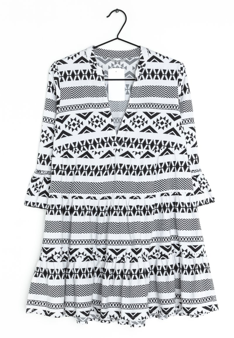 Černobíle vzorované šaty s výstřihem do V, tříčtvrtečními rukávy a vrstveným volánkovým lemem; obsahují geometrické motivy po celé látce.