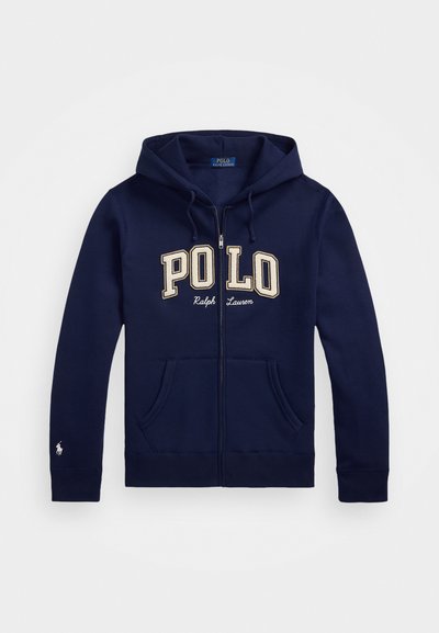 Tumesinine tõmblukuga kapuutsiga särk, mis on valmistatud puuvillast, ja millel on suured beežid tähed "POLO", kaks eesmist taskut ja väike logo varrukal.