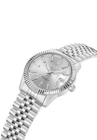 Reloj analógico plateado con esfera de metal cepillado, bisel rotatorio con borde de moneda y pulsera de acero inoxidable enlazada. Cuenta con una ventana de fecha.