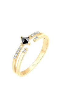 Anello in tonalità oro con una pietra centrale triangolare nera, adornato da piccoli cristalli trasparenti lungo un design di fascia attorcigliata.