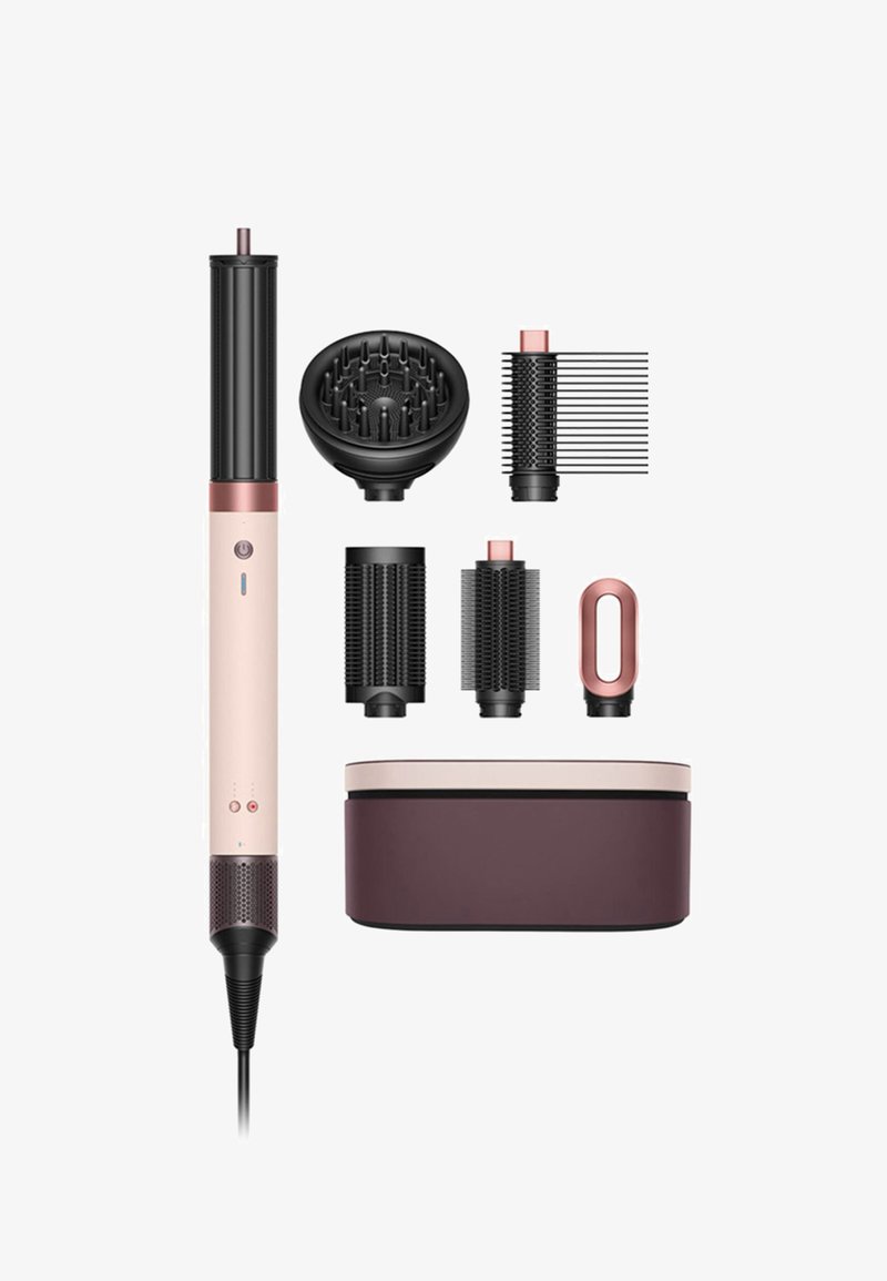 Il set di strumenti per acconciare i capelli include una spazzola riscaldata rose gold e nera, accessori per lo styling e una custodia coordinata. Diverse superfici testurizzate sono visibili.