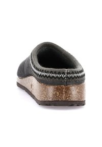 Scarpa nera in lana slip-on con retro arrotondato, bordatura grigia testurizzata e suola in gomma tipo sughero con un leggero plateau e motivi antiscivolo.