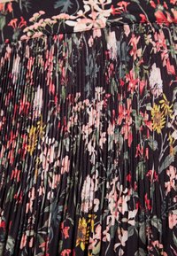 Plisseret blomsterskørt med sort baggrund, der har flerfarvede blomster i nuancer af pink, gul og grøn. Blød stofstruktur.