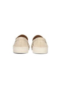 Scarpe slip-on in suede beige con punta arrotondata, interno imbottito e suola in gomma bianca sporca, con dettagli di cucitura minimalisti.