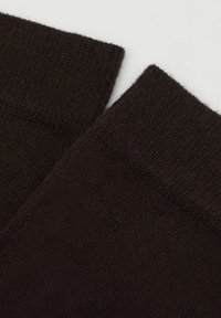 Calcetines marrones con puños acanalados, hechos de una tela suave y texturizada. El color es uniforme, sin patrones visibles ni herrajes.