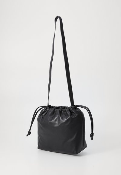 Schwarze Lederzugtasche mit einer weichen, zerknitterten Textur. Verfügt über einen dünnen Riemen und einen gerafften oberen Abschluss. Kompaktes Design.
