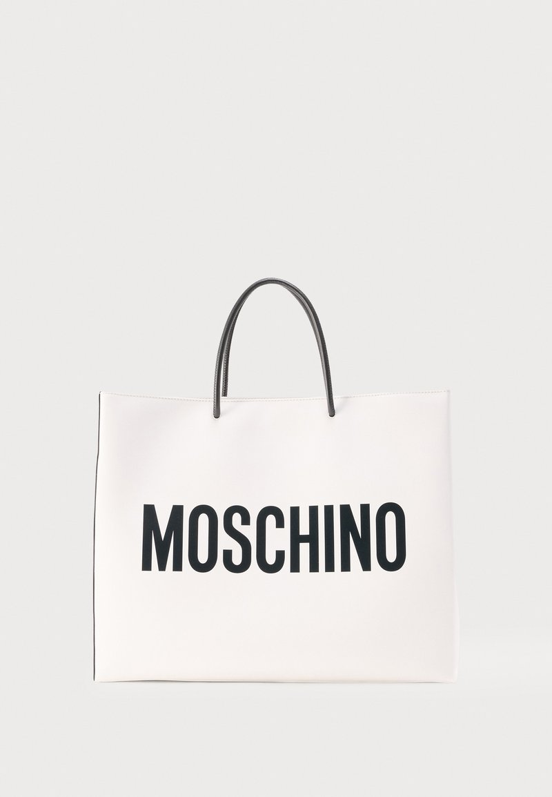 Sac cabas rectangulaire blanc avec poignées noires et grand texte noir « MOSCHINO » à l'avant sur fond uni.