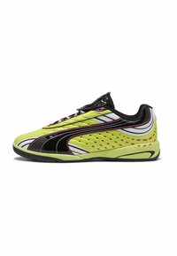 Scarpe sportive verdi e nere con un design elegante, dotate di perforazioni, accenti rosa a contrasto e una finitura testurizzata.