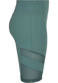 Leggings verdi a vita alta con un tessuto morbido e pannelli in rete sui lati, caratterizzati da un design aderente e lunghezza a metà coscia.