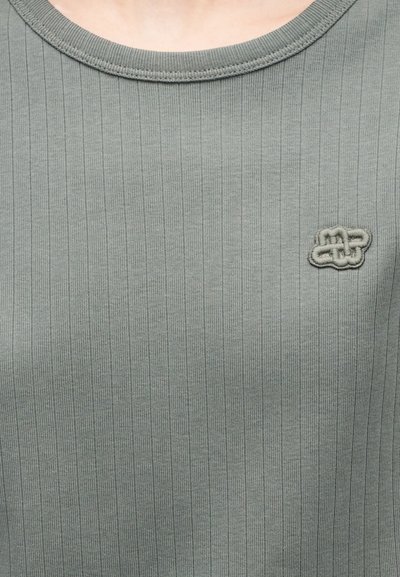 Ανοιχτό πράσινο ριμπ κοντομάνικο τοπ με στρογγυλή λαιμόκοψη και μικρό κεντητό λογότυπο στο αριστερό στήθος. Μαλακή υφή, εφαρμοστό σχέδιο.