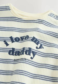 Prijetna kratka srajca s črtami v kremni barvi in mornarsko modrimi črtami. Ima rebrasto teksturo in napis »i love my daddy« v mornarsko modri barvi.