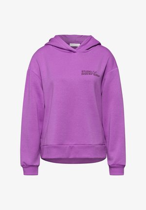Sudadera con capucha morada hecha de tela suave, con un ajuste relajado, puños y dobladillo de canalé, y letras que dicen "STUDIO Otoño 2025 Edición 84".