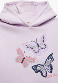 Sudadera de color púrpura claro con tres diseños de mariposa en rosa, lavanda y negro, con acentos plateados, y texto en rosa y rojo.