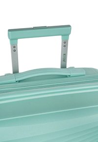 Maleta dura en color turquesa con un mango retráctil plateado, superficie texturizada y cierre de doble cremallera. Presenta un logo en relieve.