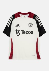 Maillot de soccer blanc à manches courtes avec des accents noirs et bordeaux, arborant des rayures Adidas, le logo de Manchester United et le texte "Tezos".