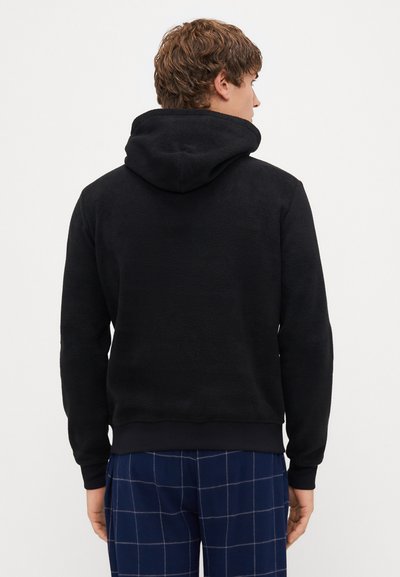 Μαύρο φλις φούτερ με μεγάλο κεφαλοσούφρακο, ριμπ στρίφωμα και μανσέτες. Το ύφασμα έχει απαλή υφή: οπίσθια όψη που δείχνει το απλό μαύρο σχέδιο.