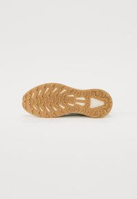 Semelle extérieure en caoutchouc brun avec un motif de grip texturé, présentant un accent triangulaire central, conçu pour l'adhérence et la stabilité.