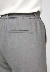 Grijze broek met een zachte textuur, elastische tailleband en een enkele achterzak met een horizontale opening.