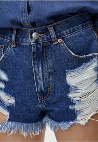 Shorts in denim con bordi sfrangiati, tessuto blu invecchiato con leggeri dettagli strappati e chiusura con bottone in vita.