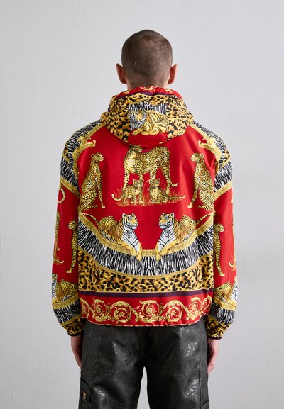Röd mönstrad hoodie med illustrationer av leopard och tiger, i svart och guld. Strukturerad tyg med en loose fit och huva.
