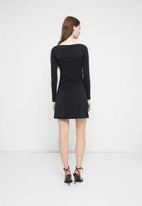 Melnas kleitas ar garām piedurknēm, piestiprinātu korseti un izvērstu svārku. Aizmugurē ir rievots dizains un kvadrātveida kakla izgriezums.