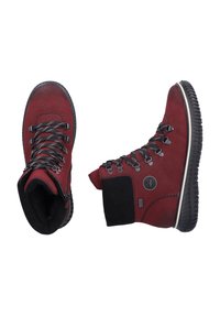 Czerwone zamszowe botki za kostkę z czarnymi sznurówkami, wyściełanym kołnierzem i teksturowaną gumową podeszwą. Posiadają okrągłe logo na boku.