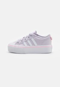 Ljuslila canvas sneakers med vita ränder, gummitåhätta och kontrasterande rosa accent på sulan, med runda snörning och låg profil.