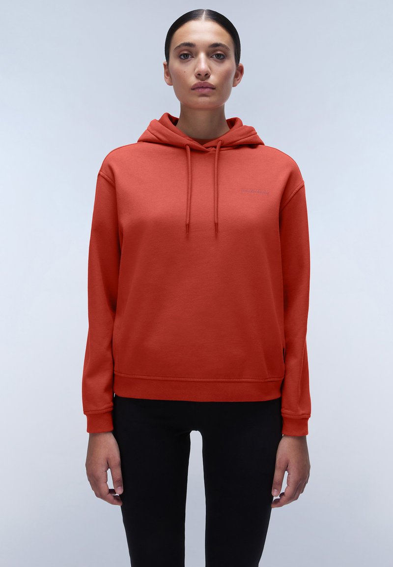 Rote Kapuzenjacke mit Kordelzug, gerippten Bündchen und Saum. Glatte Textur mit kleinem Logo auf der Brust. Kombiniert mit schwarzen Leggings.