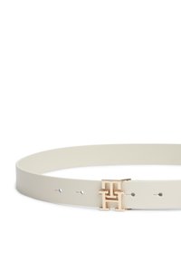 Λευκή δερμάτινη ζώνη με ομαλή υφή, διακοσμημένη με γεωμετρική αγκράφα σε χρυσό τόνο και πέντε τρύπες για ρύθμιση μεγέθους.