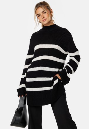 Zwart-wit gestreepte oversized gebreide trui met een hoge hals en lange mouwen, met een ontspannen pasvorm en zijzakken.