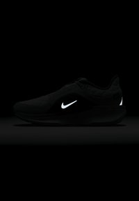 Basket noire Nike avec une tige texturée, arborant un logo blanc et des accents réfléchissants subtils ; design moderne, silhouette élégante, semelle en caoutchouc.