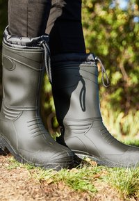 Black waterproof boots with a smooth, textured finish, rounded toe, and elastic drawstring at the top for a secure fit. Rubber sole with grip.