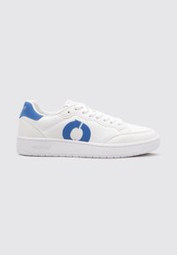 Zapatilla blanca con un logo circular azul, material sintético liso, diseño con cordones y una suela texturizada. Con un refuerzo en el talón azul.