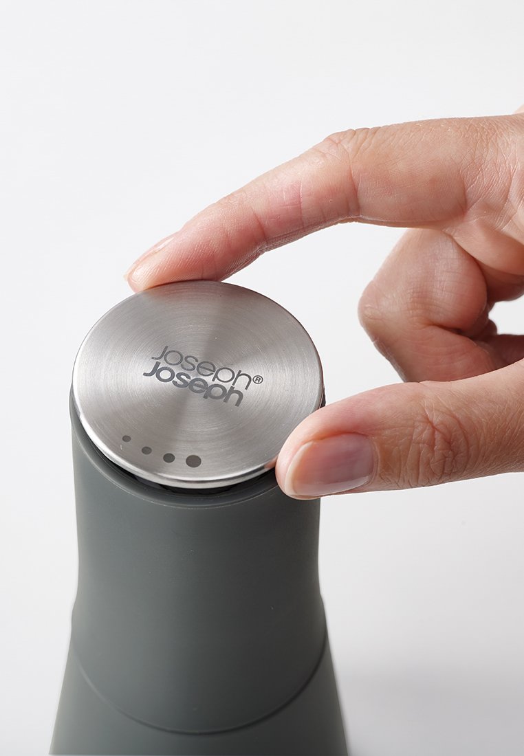 Zoutvaatje met een matte grijze behuizing en een metallic zilveren bovenkant. De bovenkant heeft een gegraveerd logo en vijf kleine gaatjes voor het doseren.