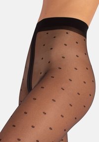 Motivo a pois neri su collant neri trasparenti, con ampia cintura elastica e texture liscia. Ideali per sovrapporre o per un look informale.