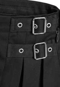 Jupe en tissu noir avec deux sangles horizontales dotées de boucles rectangulaires argentées et d'œillets, ainsi qu'une fermeture éclair latérale visible.