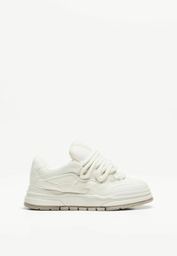 Baskets blanches avec une tige texturée, un bout arrondi, une semelle épaisse et des lacets proéminents. Design simple avec des détails de couture subtils.