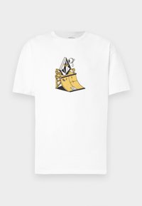 T-shirt bianco in cotone con un'illustrazione grafica di una ramпа per skateboard con un personaggio in giacca e cravatta, delineato in dettagli neri e gialli.