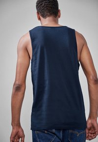 Sininen ilmanhiha tank top, valmistettu pehmeästä puuvillasta, jossa on rento malli ja pyöreä pääntie, yhdistettynä farkkuihin.