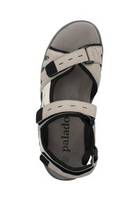 Beige sandaler med svarta detaljer, utrustade med justerbara remmar, en vadderad innersula och en mönstrad sula för bra grepp. Vadderad inuti för komfort.