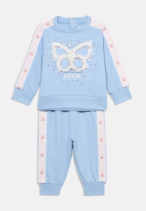 Ensemble sweat-shirt en coton bleu clair et pantalon assorti avec un motif papillon, des paillettes et des accents de logo sur les manches et les jambes.
