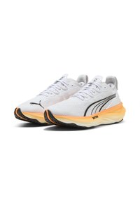 Zapatillas de running blancas con una parte superior de malla texturizada, detalles negros en los laterales y una suela naranja sobredimensionada para amortiguación y soporte.