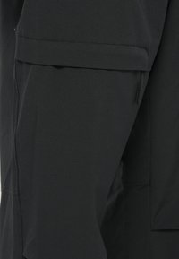 Μαύρο παντελόνι με απαλό, ελαφρύ ύφασμα, που διαθέτει πλαϊνές τσέπες και καθαρή ραφή. Ο σχεδιασμός είναι λειτουργικός και κομψά ραμμένος.