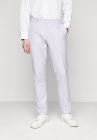 Helle lila Hosen aus glattem Stoff, mit geradem Schnitt, seitlichen Taschen und flacher Vorderseite, getragen mit weißen Sneakers.