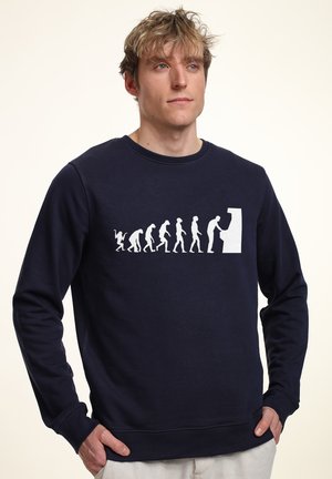 Námořnická mikina s bílou grafikou evoluce, kulatým výstřihem, dlouhými rukávy, ribbovanými manžetami a volným střihem. Měkký materiál z bavlněné směsi.