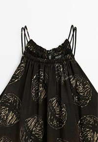 Robe noire sans manches avec fines doubles bretelles, présentant un motif circulaire abstrait beige et un col froncé élastique avec détail bouton.