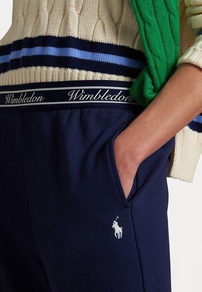 Mørkeblå sweatpants har en talje med "Wimbledon" skrift, sidelommer og et hvidt broderet polo-logo på låret.