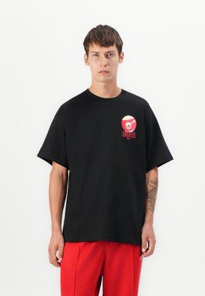 Black cotton t-shirt with a loose fit. Features a colorful circular logo on the chest with red and yellow accents. Short sleeves.