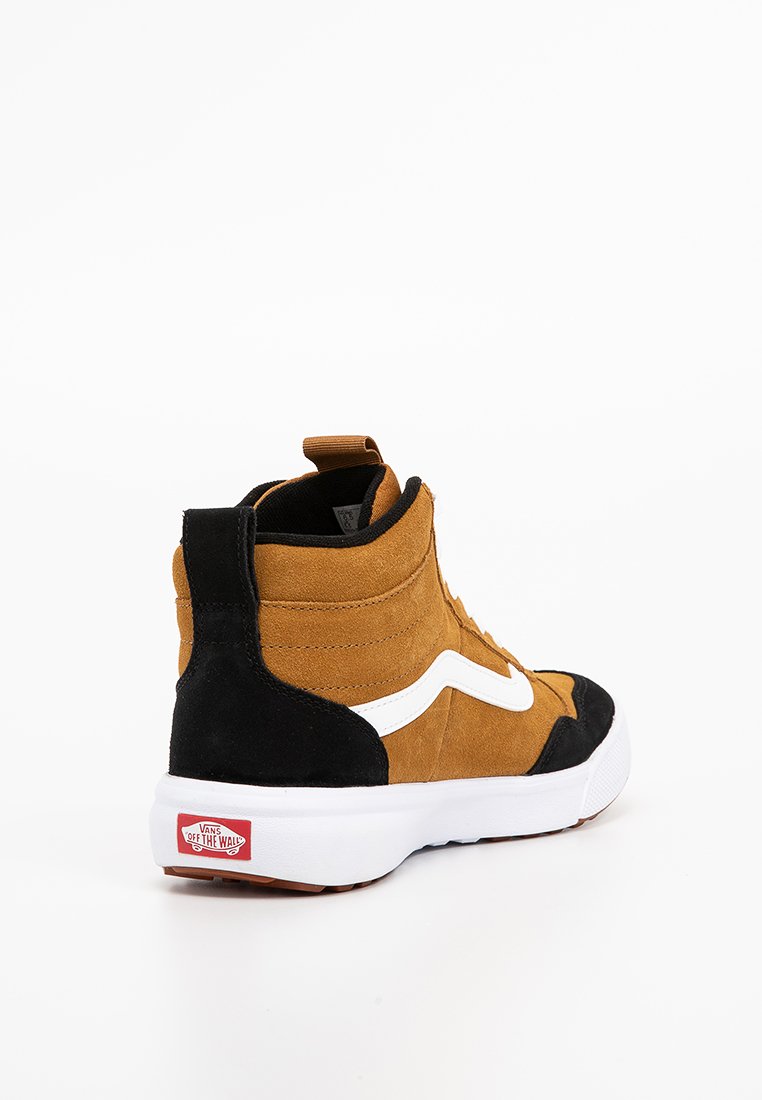 Zapatilla alta de ante marrón y negro con logotipo blanco, suela de goma y etiqueta roja "Vans Off the Wall" en el talón.